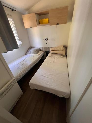 Cette petite chambre comprend 2 lits. dans l'établissement MOBIL-HOME 3 CHAMBRES LA TESTE DE BUCH, à La Teste-de-Buch