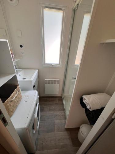 une petite salle de bain avec un lavabo et une fenêtre dans l'établissement MOBIL-HOME 3 CHAMBRES LA TESTE DE BUCH, à La Teste-de-Buch