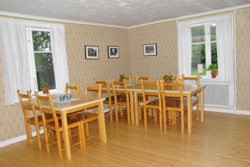 a dining room with a table and chairs and windows at Åsens By in Haurida