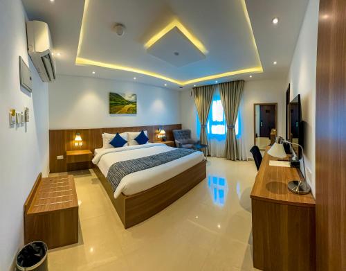 杜科姆Duqm Express Hotel的配有床和书桌的酒店房间
