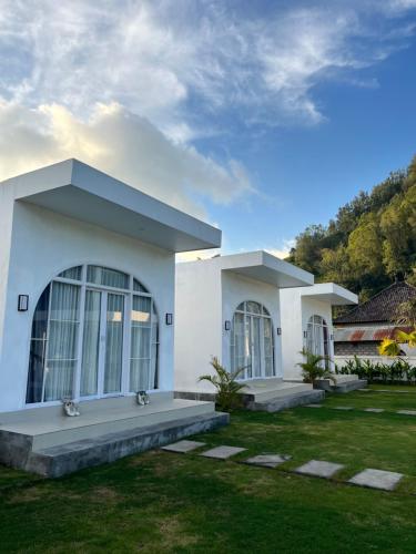 a white house with a lawn in front of it at Volcano Garden in Kubupenlokan
