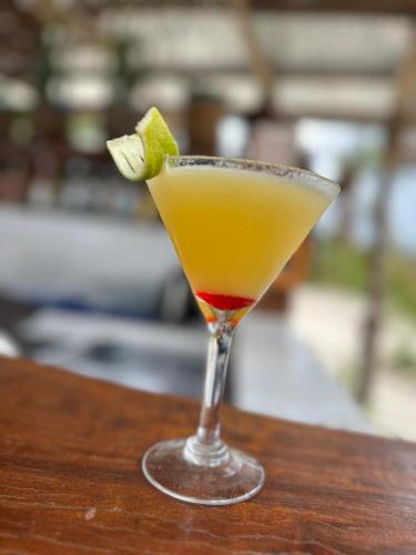 a drink in a martini glass on a wooden table at Kiwengwa Bungalow Boutique Resort in Kiwengwa