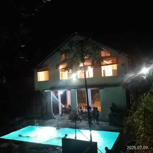 a house with a swimming pool at night at Kit Cott Resort and Retreat in Teligama