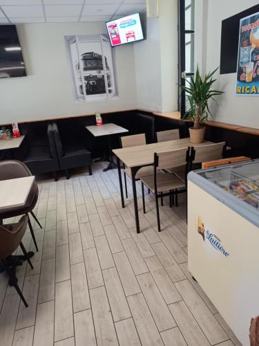 a restaurant with tables and chairs and a counter at Hôtel des 2 Gares in Nevers