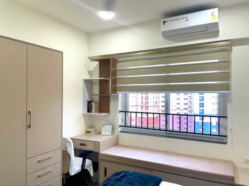 a room with a window with a desk and a window blind at Luxury Studio Apartment in Trivandrum