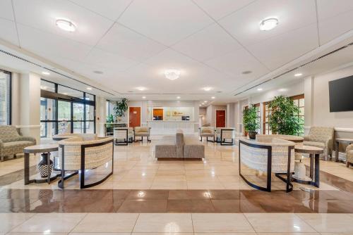 a lobby with tables and chairs in a building at Clarion Hotel & Conference Center in Toms River