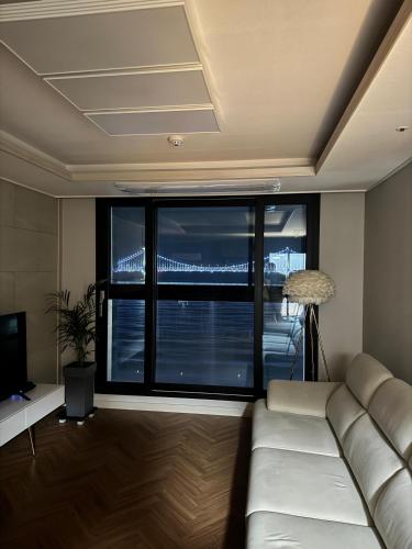 a living room with a couch and a large window at Casa Felice in Busan