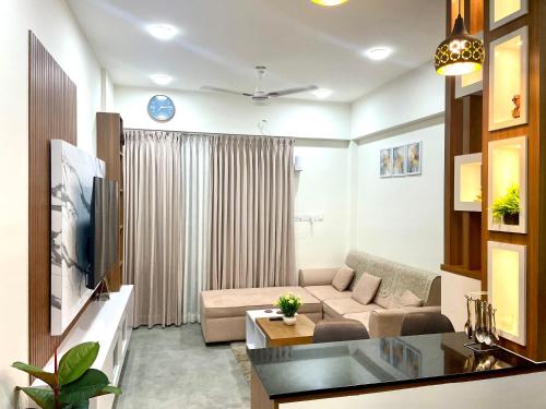 a living room with a couch and a tv at Luxury Studio Apartment in Trivandrum