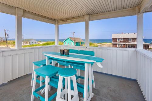 un porche avec une table bleue et des tabourets dans l'établissement 4080 - Betcha Like It, à Kitty Hawk