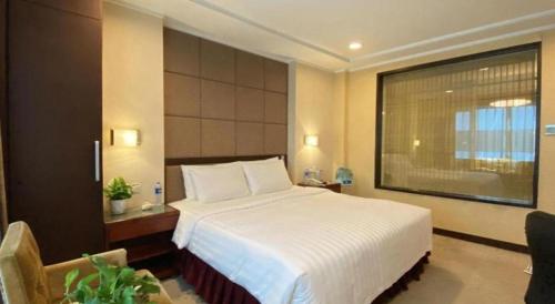 a bedroom with a white bed and a large window at Changchun Zhuozhan Days Hotel in Changchun