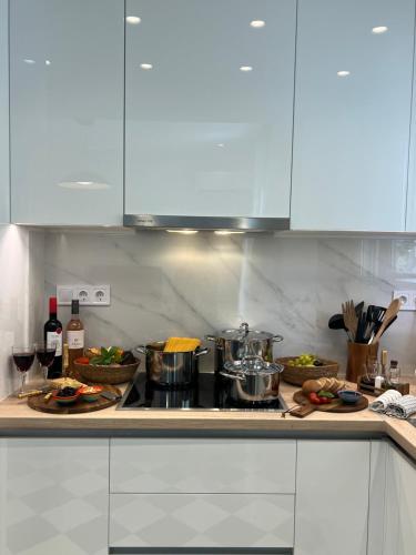 a kitchen with white cabinets and food on a counter at KK Athens Fine Stay-Steps to Metro-Modern & Cozy Apartments in Athens