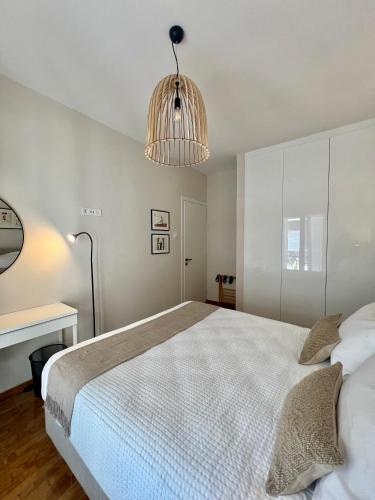 a bedroom with a large bed and a chandelier at KK Athens Fine Stay-Steps to Metro-Modern & Cozy Apartments in Athens
