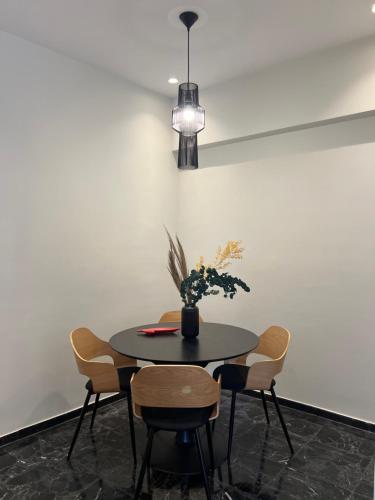 a table with chairs and a vase with flowers on it at KK Athens Fine Stay-Steps to Metro-Modern & Cozy Apartments in Athens