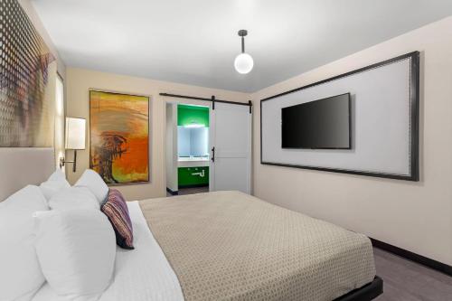 a bedroom with a bed and a flat screen tv at Heights House Hotel - Houston Heights Downtown, an Ascend Collection Hotel in Houston