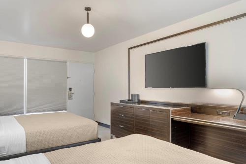 a bedroom with two beds and a flat screen tv at Heights House Hotel - Houston Heights Downtown, an Ascend Collection Hotel in Houston