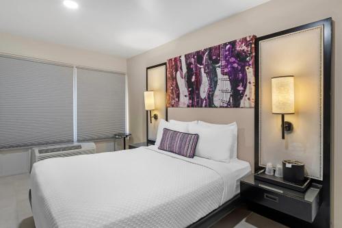 a bedroom with a white bed and a painting on the wall at Heights House Hotel - Houston Heights Downtown, an Ascend Collection Hotel in Houston