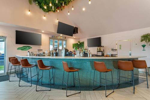 a bar in a restaurant with orange stools at Heights House Hotel - Houston Heights Downtown, an Ascend Collection Hotel in Houston