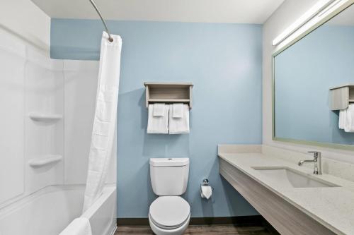 a bathroom with a toilet and a tub and a sink at WoodSpring Suites Anderson North I-85 in Anderson