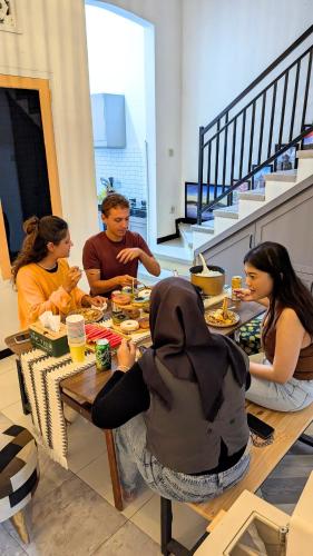 a group of people sitting at a table eating at Casa de Vie Homestay in Malang