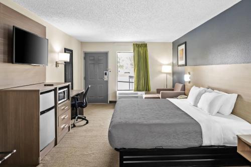 a hotel room with a bed and a flat screen tv at Quality Inn Oak Grove Fort Campbell in Oak Grove