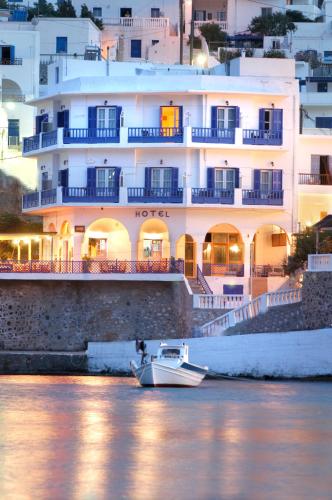 a boat in the water in front of a building at Paradissos Hotel in Pera Gyalos