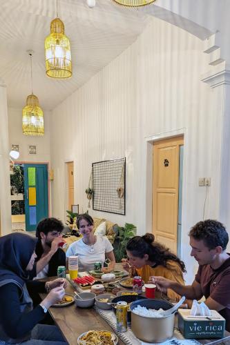 a group of people sitting around a table eating food at Casa de Vie Homestay in Malang