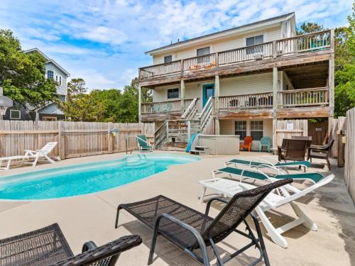 a patio with chairs and a swimming pool at 1662 - Dune Our Thing in Corolla