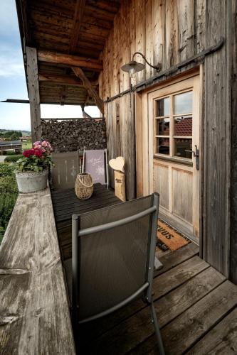 a table and a chair on a wooden deck at Ferienwohnung Allgäutraum mit Bergblick in Oy-Mittelberg