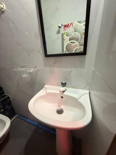 a white sink in a bathroom with a mirror at Roshini Homestay Hampi in Hampi