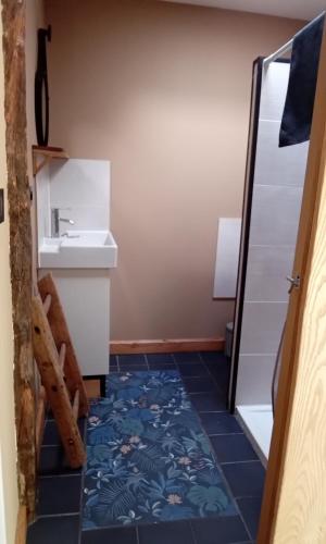 La salle de bains est pourvue d'un lavabo et de carrelage bleu. dans l'établissement Gîte,bergerie en moyenne montagne, à Lacaze