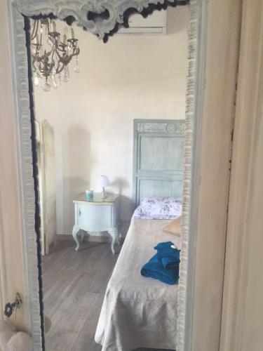 a mirror in a bedroom with a bed and a desk at B.E.A. Maison in La Spezia
