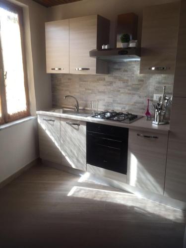 a kitchen with a stove and a sink and a window at B.E.A. Maison in La Spezia