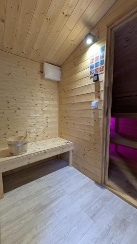 a wooden sauna with a bench in a room at Koło Żółwia in Gąski