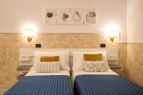 a bedroom with two beds and two lamps at Hotel Ascot in Rome