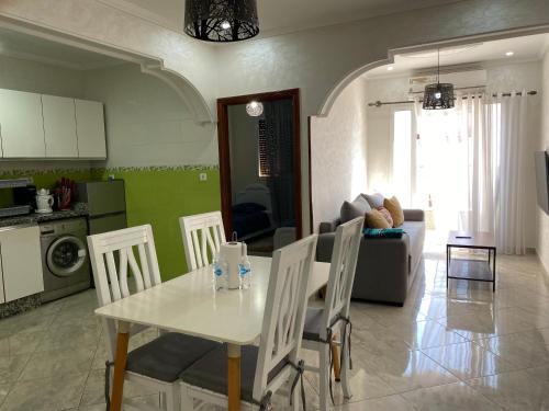 a kitchen and living room with a table and chairs at City Center Blue Pearl in Al Hoceïma