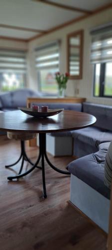 a living room with a table and a couch at Leśna Aura in Ponizie