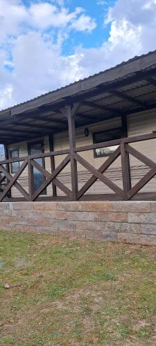 a wooden fence with a roof on top of a building at Leśna Aura in Ponizie