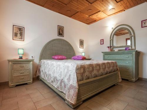 una camera con un letto, due cassettiere e uno specchio di Casa Vacanze Nikita a Sperlonga