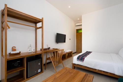 a bedroom with a bed and a desk with a computer at Green Hill Boutique Hotel in Labuan Bajo