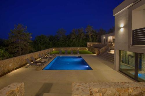a swimming pool in the backyard of a house at Villa ASTRUM with heated indoor and outdoor pool, jacuzzi and sauna in Vrh