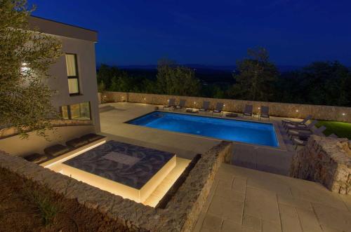 a swimming pool in the backyard of a house at Villa ASTRUM with heated indoor and outdoor pool, jacuzzi and sauna in Vrh