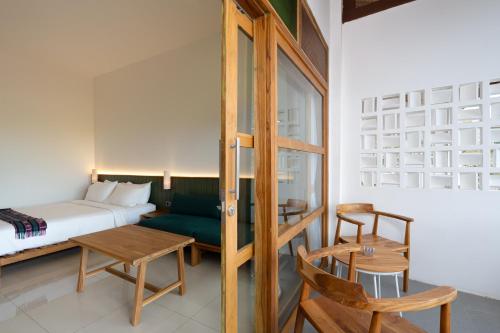 a bedroom with a bed and a table and chairs at Green Hill Boutique Hotel in Labuan Bajo