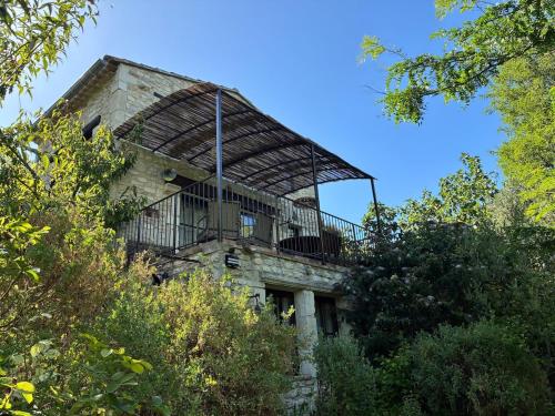 - un ancien bâtiment avec un balcon au-dessus dans l'établissement Maison en Drôme Provençale, à Montségur-sur-Lauzon