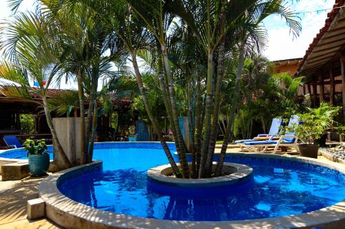 a swimming pool with palm trees in a resort at Casa Lajagua in Pedasí Town