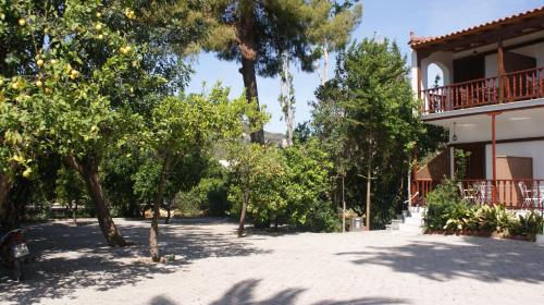 a yard with trees and a building with a balcony at Villa Christina in Tolo