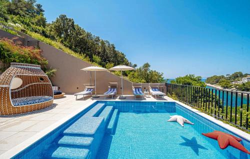 a swimming pool with some chairs at 4 Bedroom Gorgeous Home In Korcula in Korčula