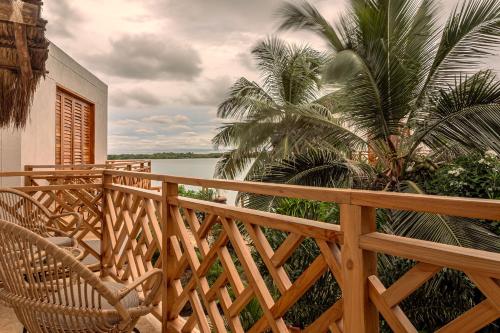 a wooden deck with a chair and palm trees at Islawa Soy Local - Isla Privada in Baru