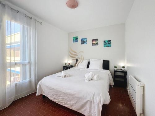 une chambre avec un lit blanc avec deux serviettes dessus dans l'établissement T2 L'Etoile du Sud -4pers-plage, port 5 min wifi parking - CapitalChic Services Fréjus Plage, à Fréjus