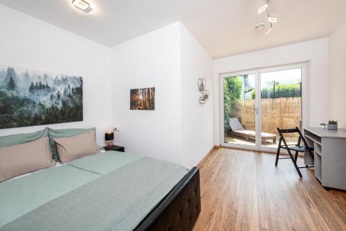 a bedroom with a bed and a desk and a window at Home Maislinger - Enjoy Nature, Explore Salzburg in Wals
