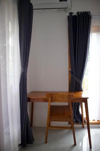 a wooden desk in a room with a window at Isirela in Kuta Lombok